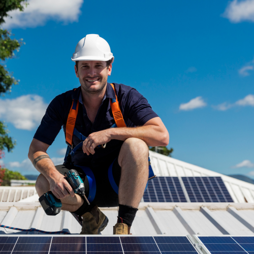 Technicien sur un toit posant des panneaux solaires
